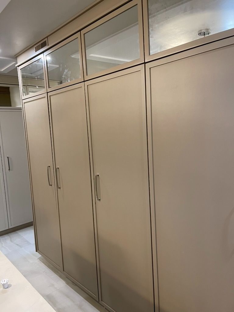 A row of cabinets with glass doors in a room.