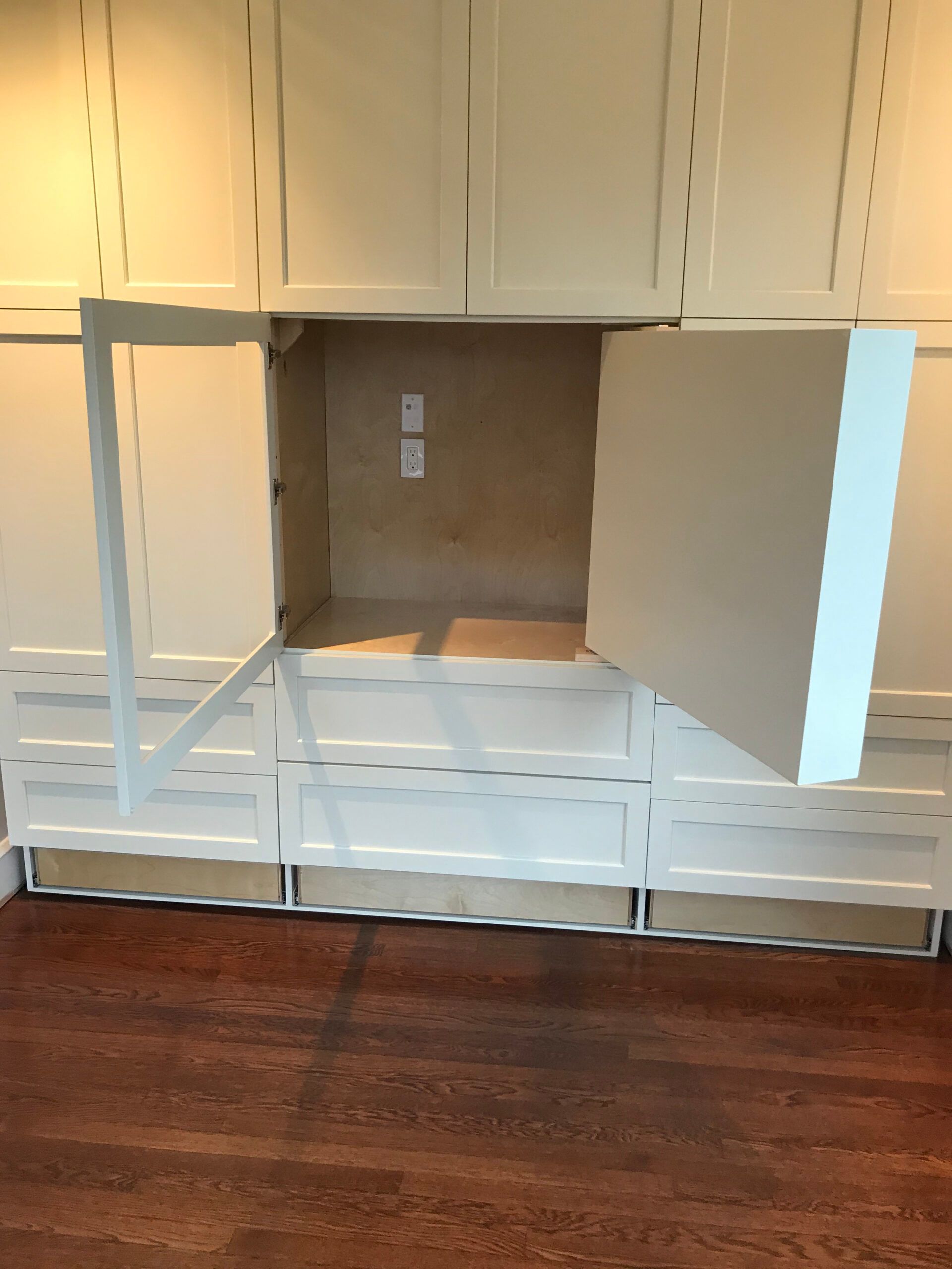 A room with white cabinets and the door open