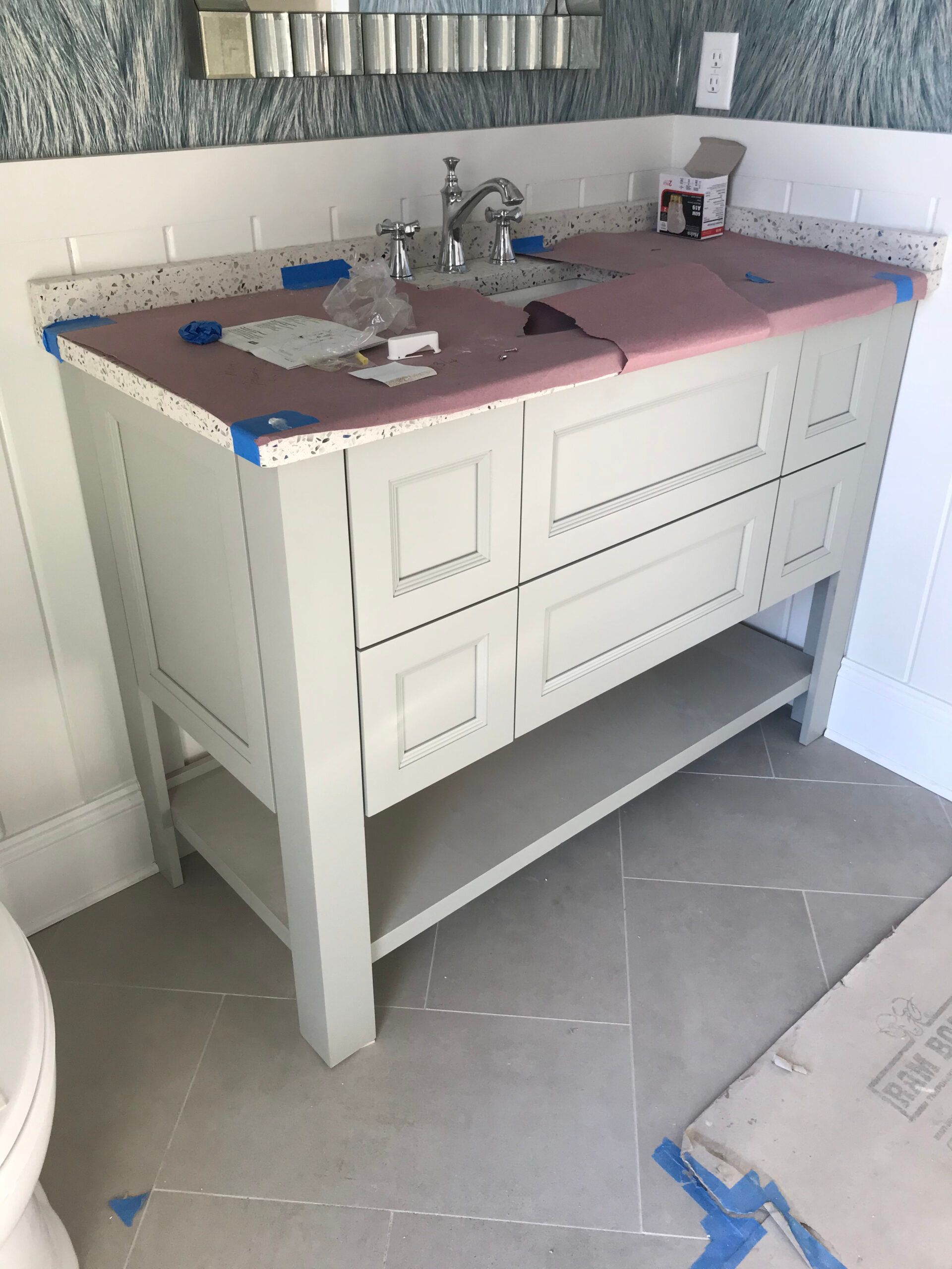 A bathroom vanity is being built in a bathroom.