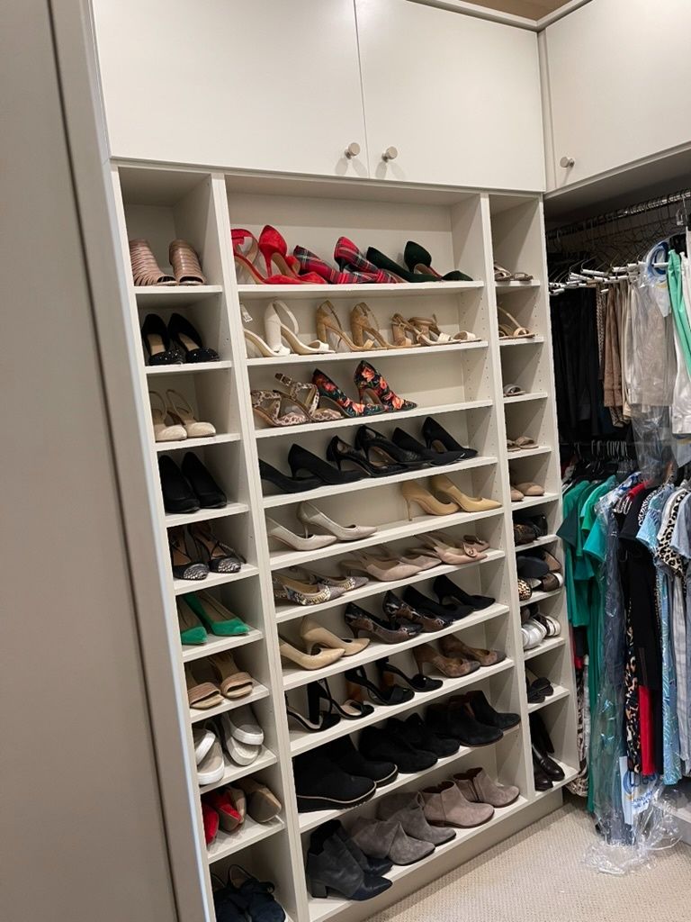 A closet filled with lots of shoes and clothes.