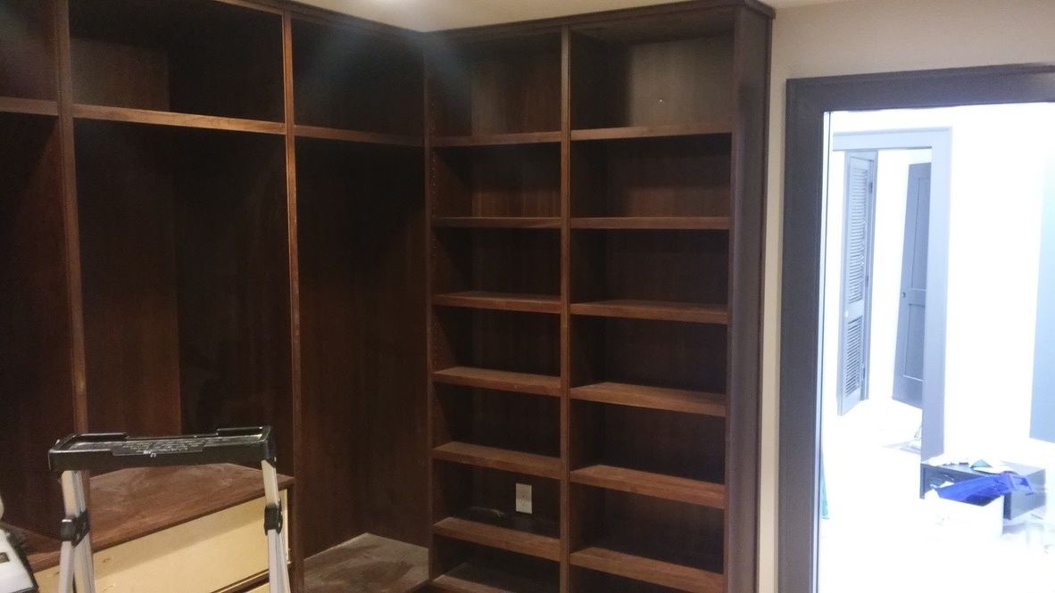 A walk in closet with lots of shelves and a door.
