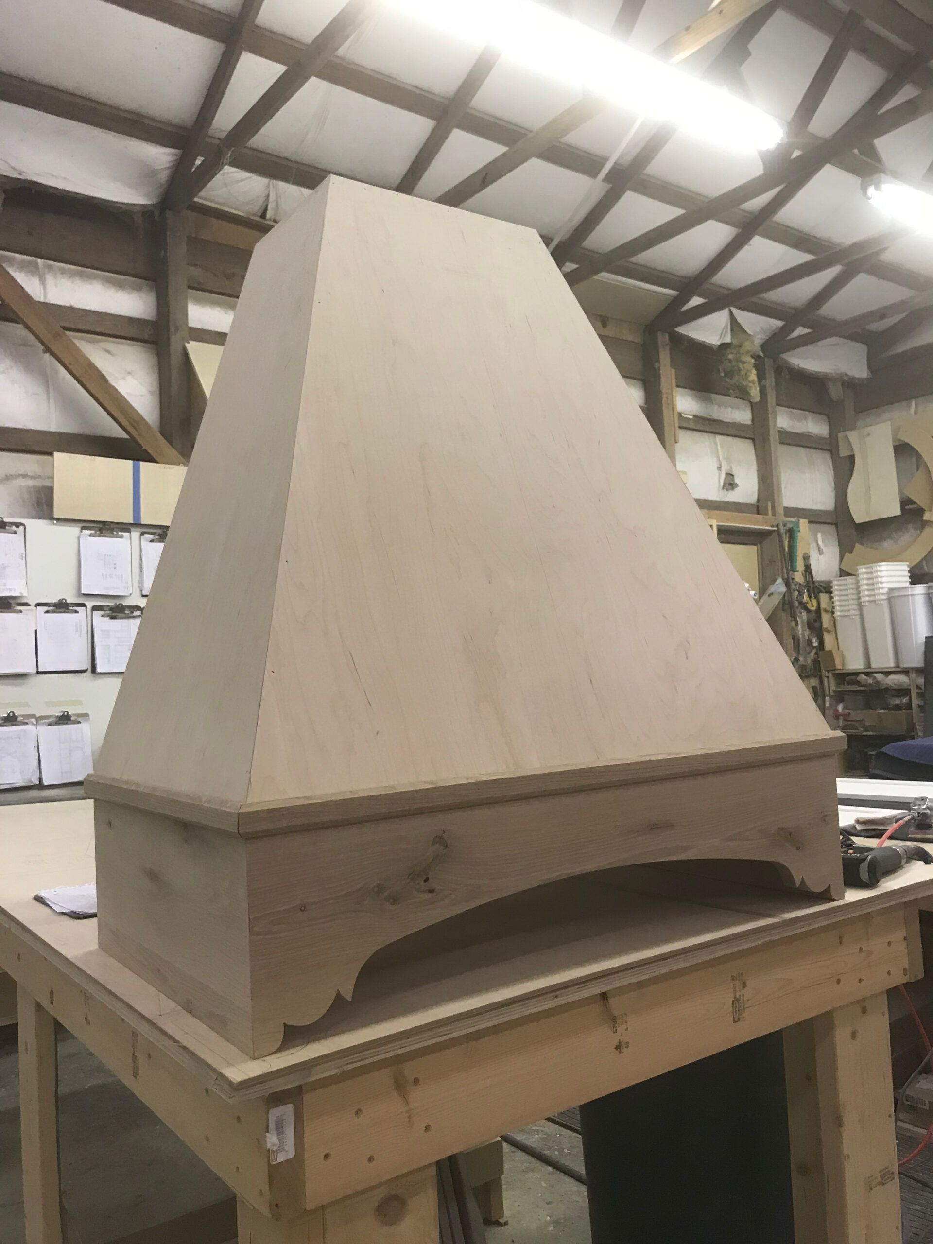 A wooden hood is sitting on top of a wooden table.