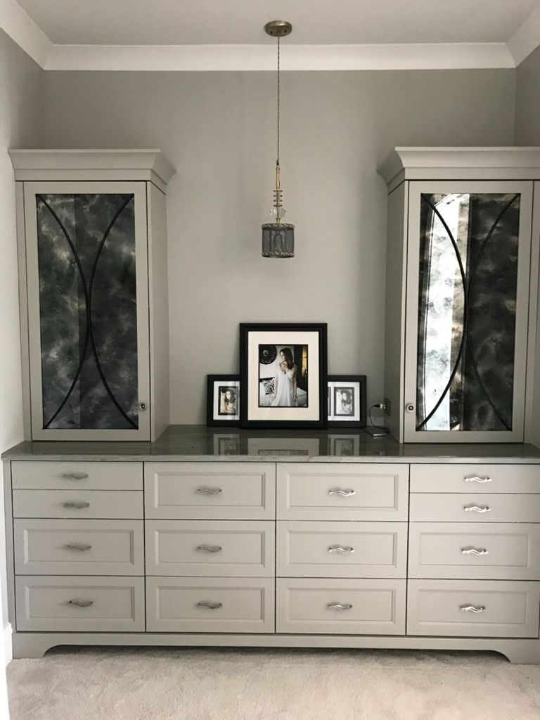 A dresser with drawers and a picture on top of it