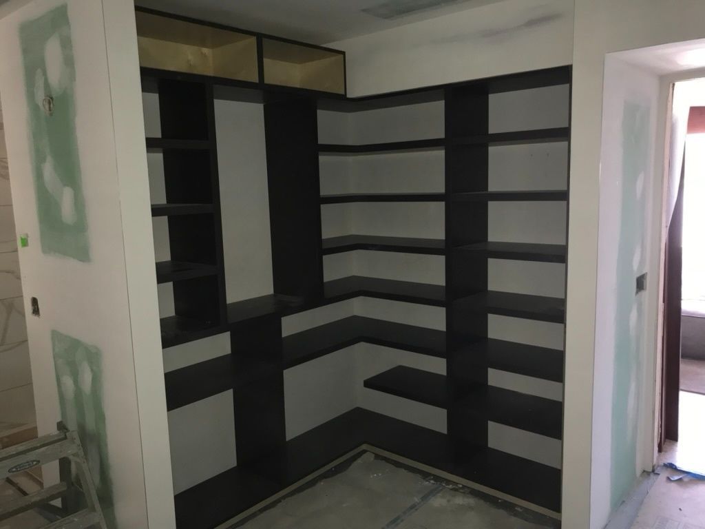 A room with a lot of shelves and a door.