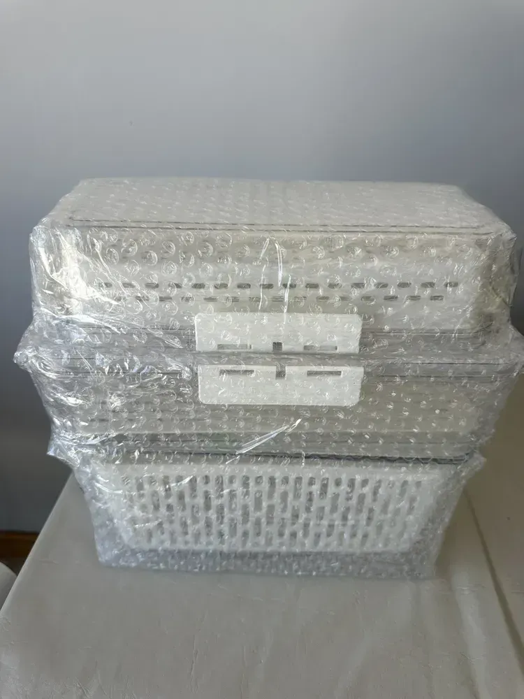 Tres recipientes de plástico transparente para almacenar alimentos, apilados y llenos de productos.