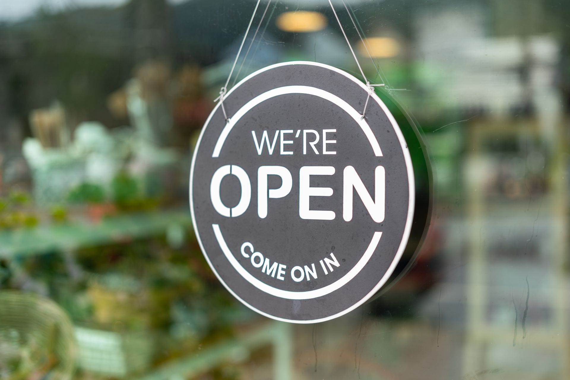 Opening banner display with text sign which is hanging at front door of the cafe, restaurant or retail store.