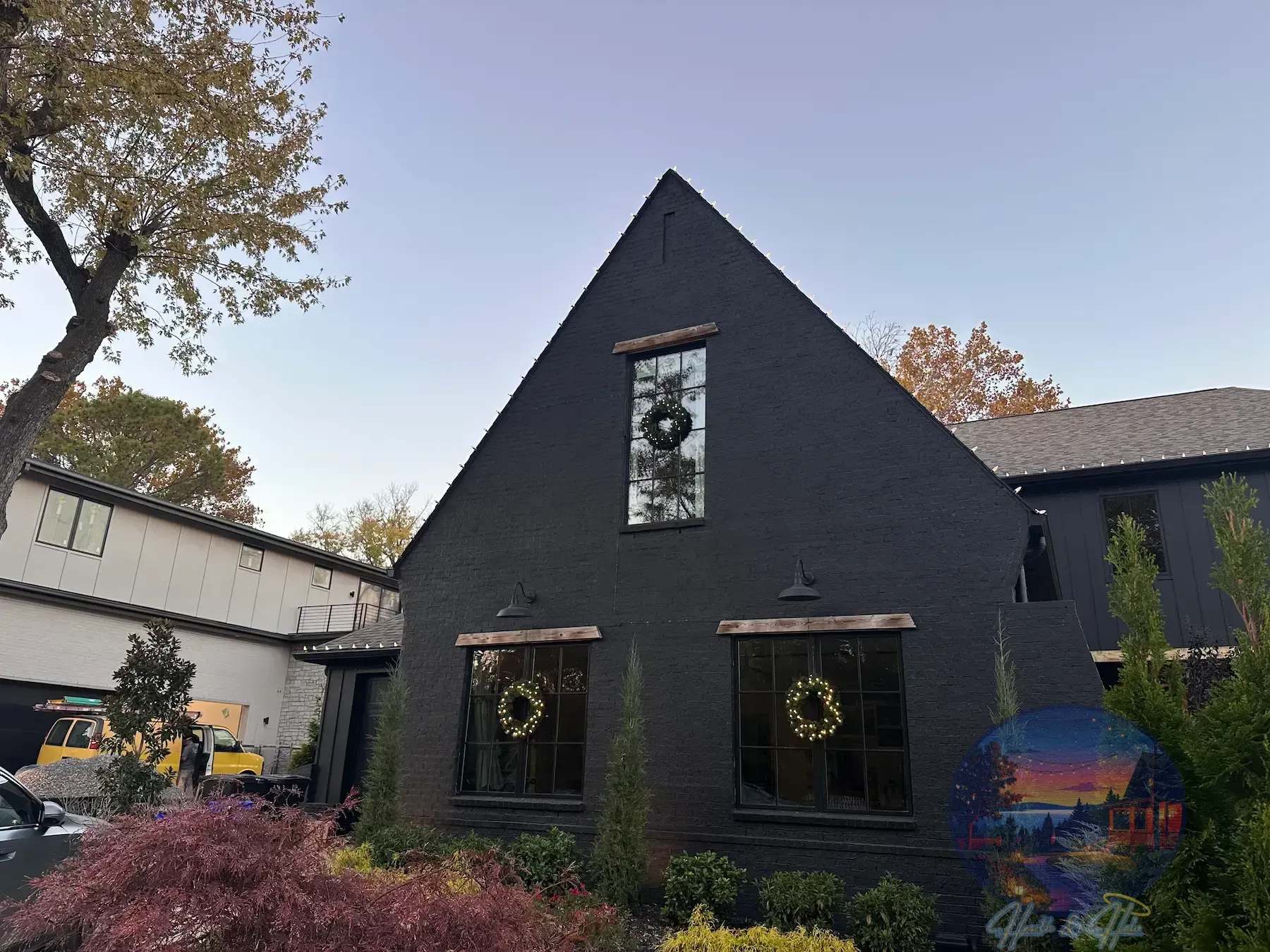 House exterior decorated with red and green Christmas lights at night.