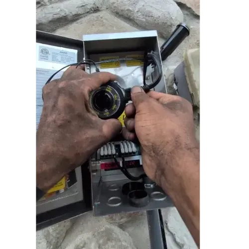 Hands with dirt working on an electrical box.