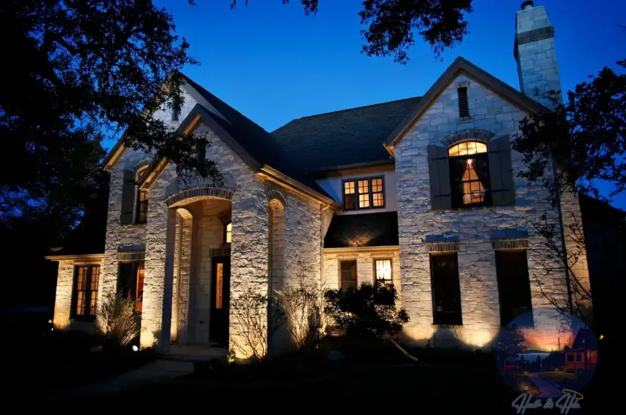 Stone house illuminated at night, blue sky, outdoor lighting.