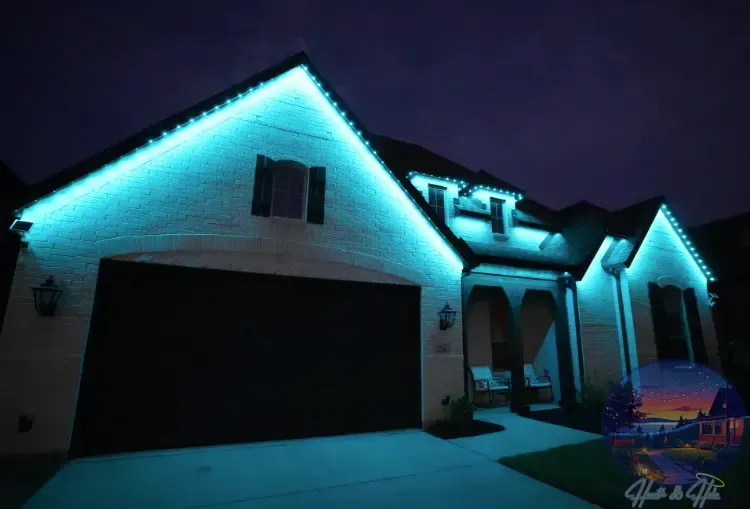 A house at night with teal lights outlining the roof and architectural features.