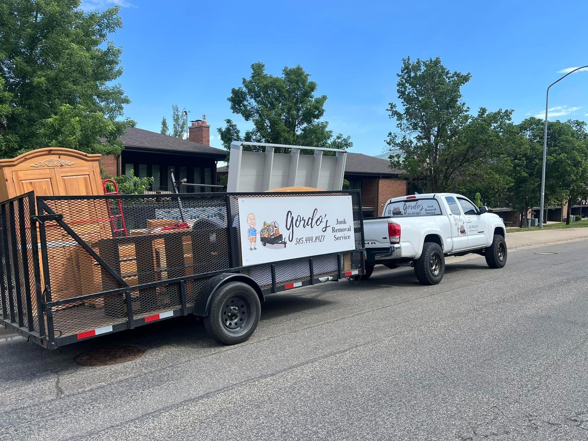 A truck and trailer are parked on the side of the road.