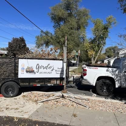 A truck with a trailer attached to it is parked on the side of the road.