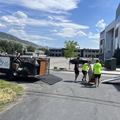 A group of people are carrying a piano down a street.