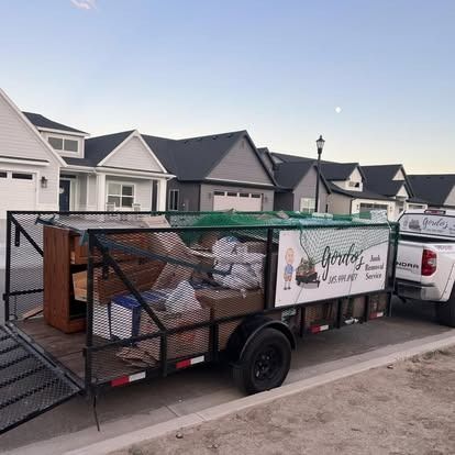 A trailer filled with junk is parked in front of a house.
