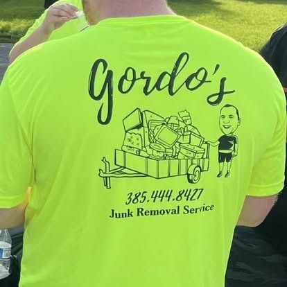 A man is wearing a neon yellow t-shirt that says gordo 's junk removal service.