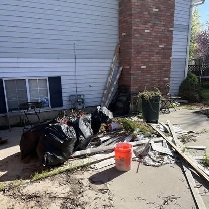 A pile of trash is sitting in front of a house.