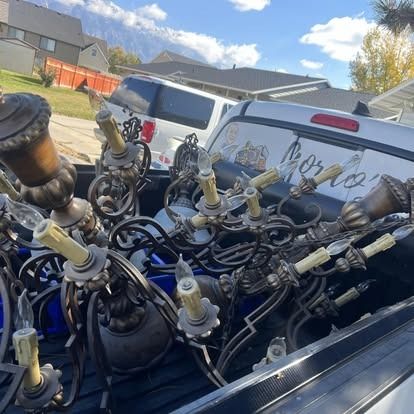 A bunch of chandeliers are in the back of a truck.
