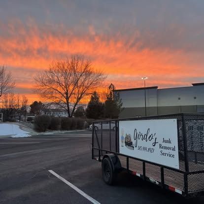 A trailer is parked in a parking lot at sunset.