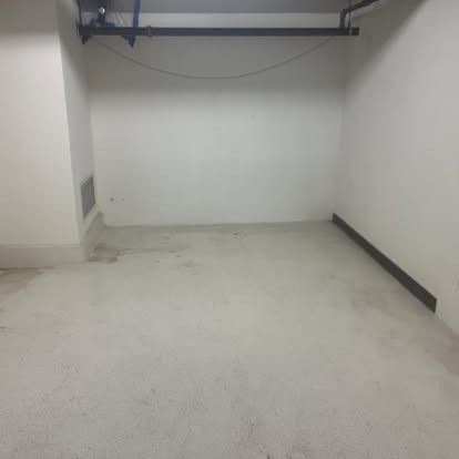 An empty garage with a white floor and white walls.