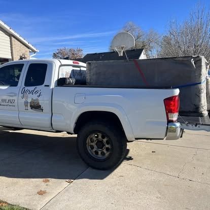 A white truck is parked in a driveway next to a house.