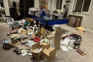 A living room filled with lots of boxes and a pool table.