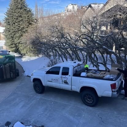 A white truck is parked in a driveway in the snow.