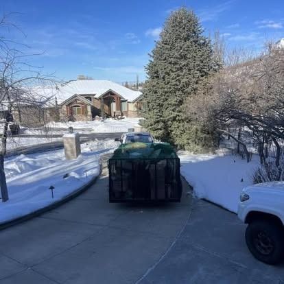 A truck is parked in front of a snow covered house.