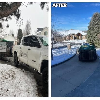 A truck is parked in the snow next to a house.