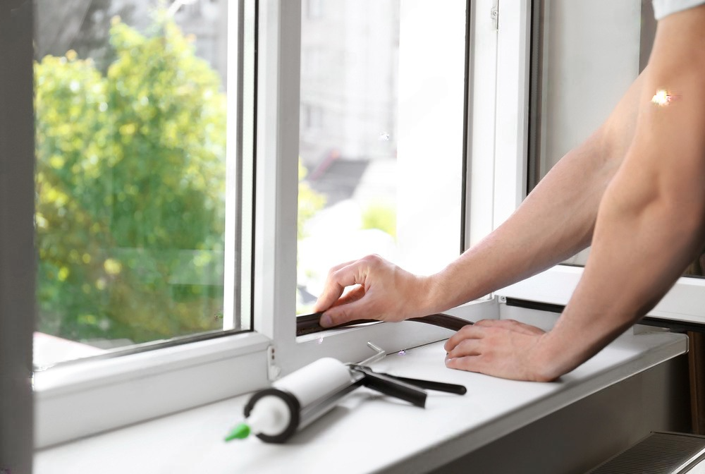 a man is installing a window on a window sill .