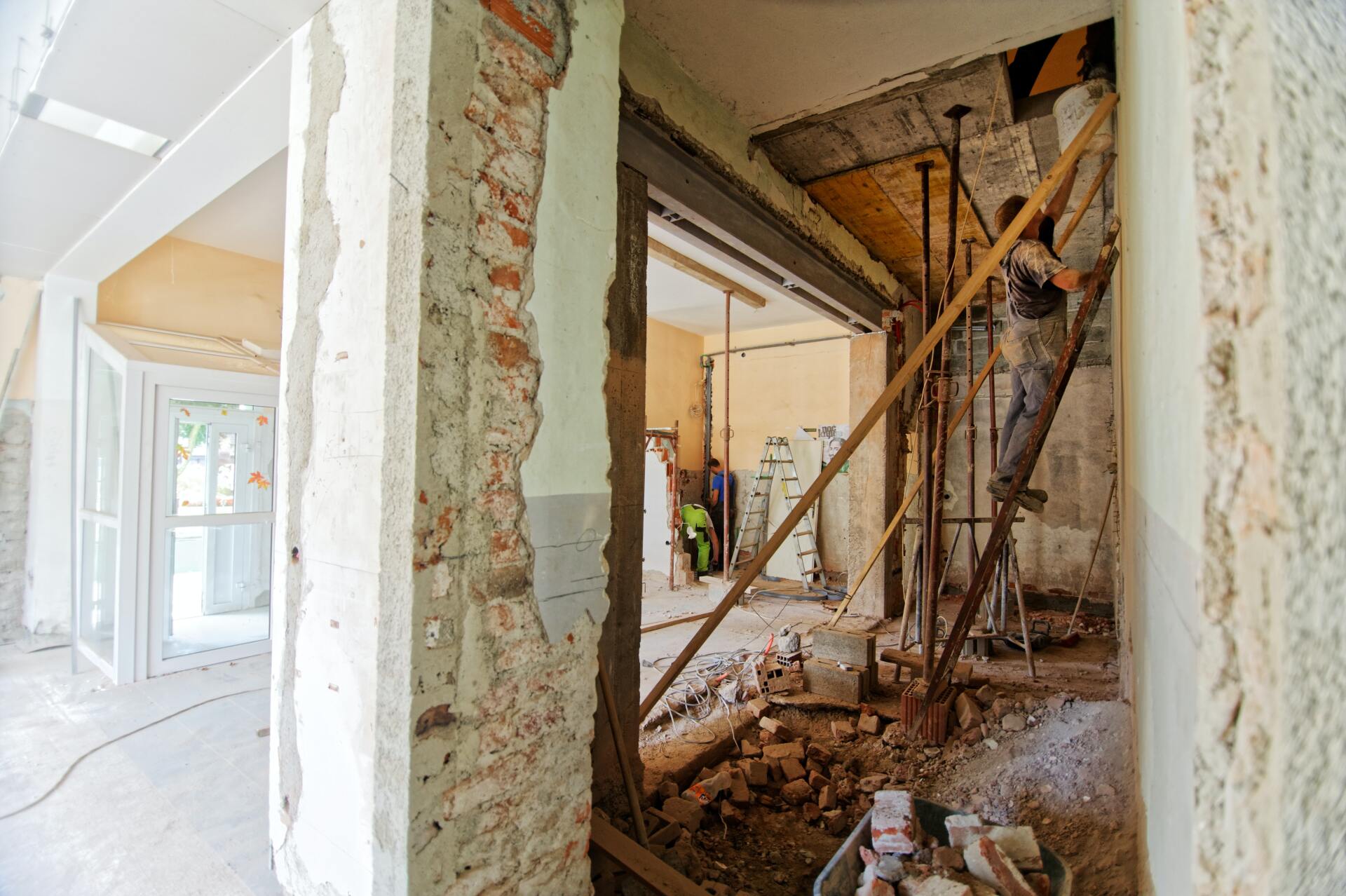 Construction workers carefully removing the ceiling in preparation for a home renovation project.