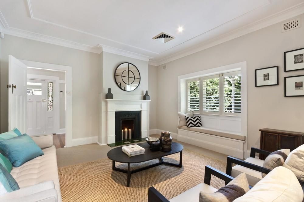 a living room with a couch , chairs , coffee table and fireplace .