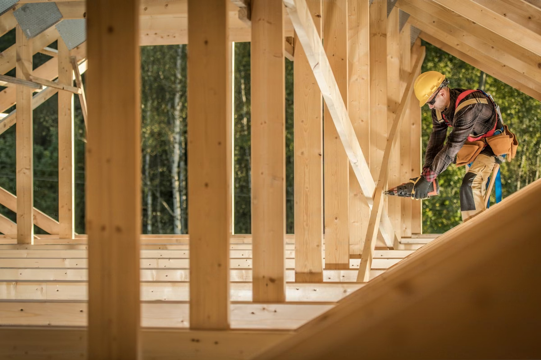 a construction worker is working on a wooden structure .