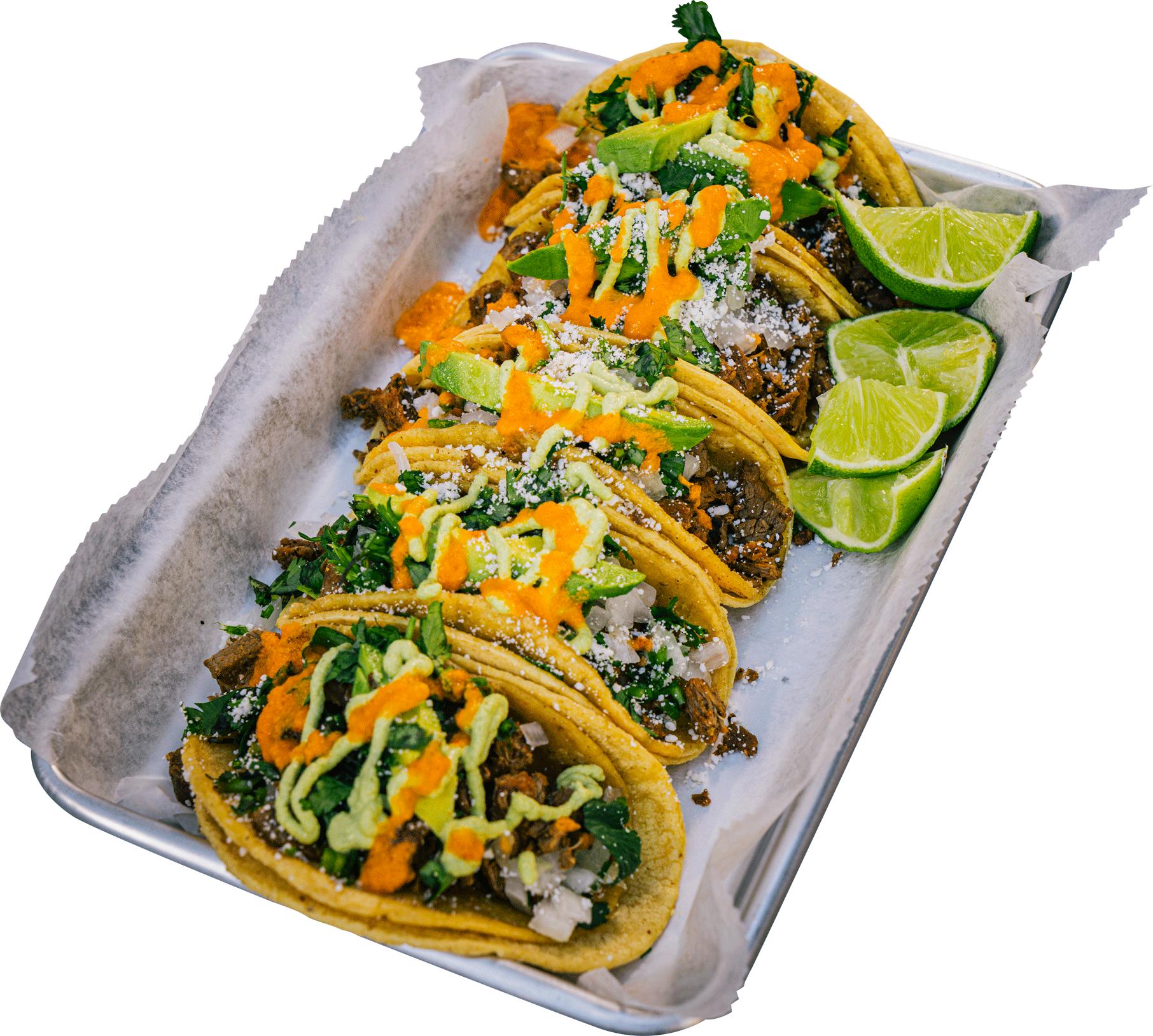 A tray of tacos with sauces and lime wedges