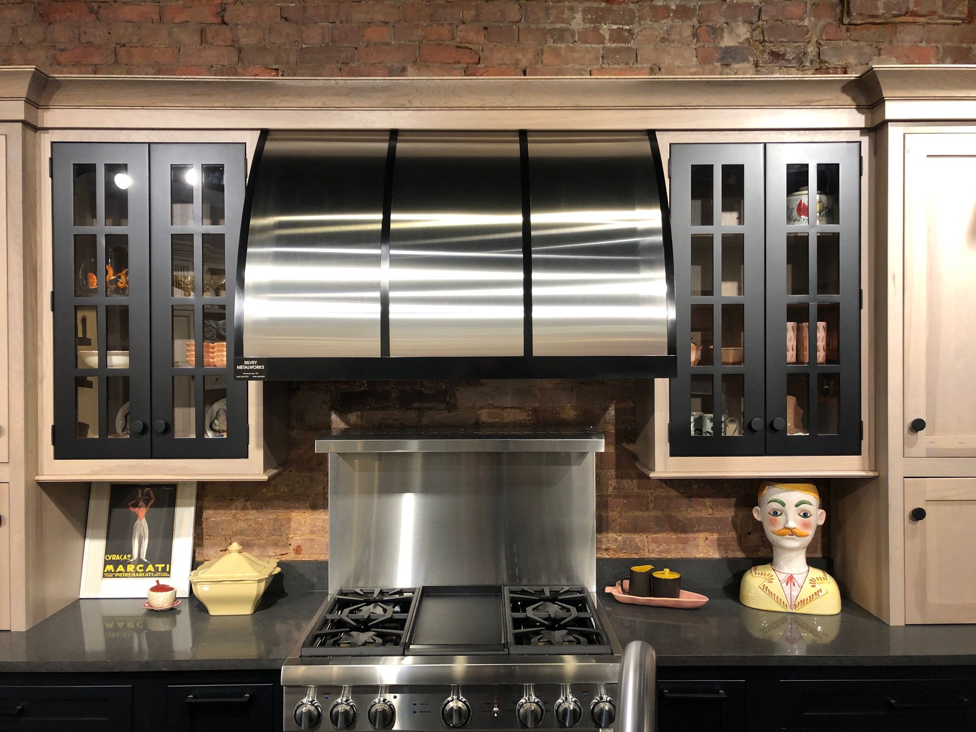 A kitchen with stainless steel appliances and black cabinets.
