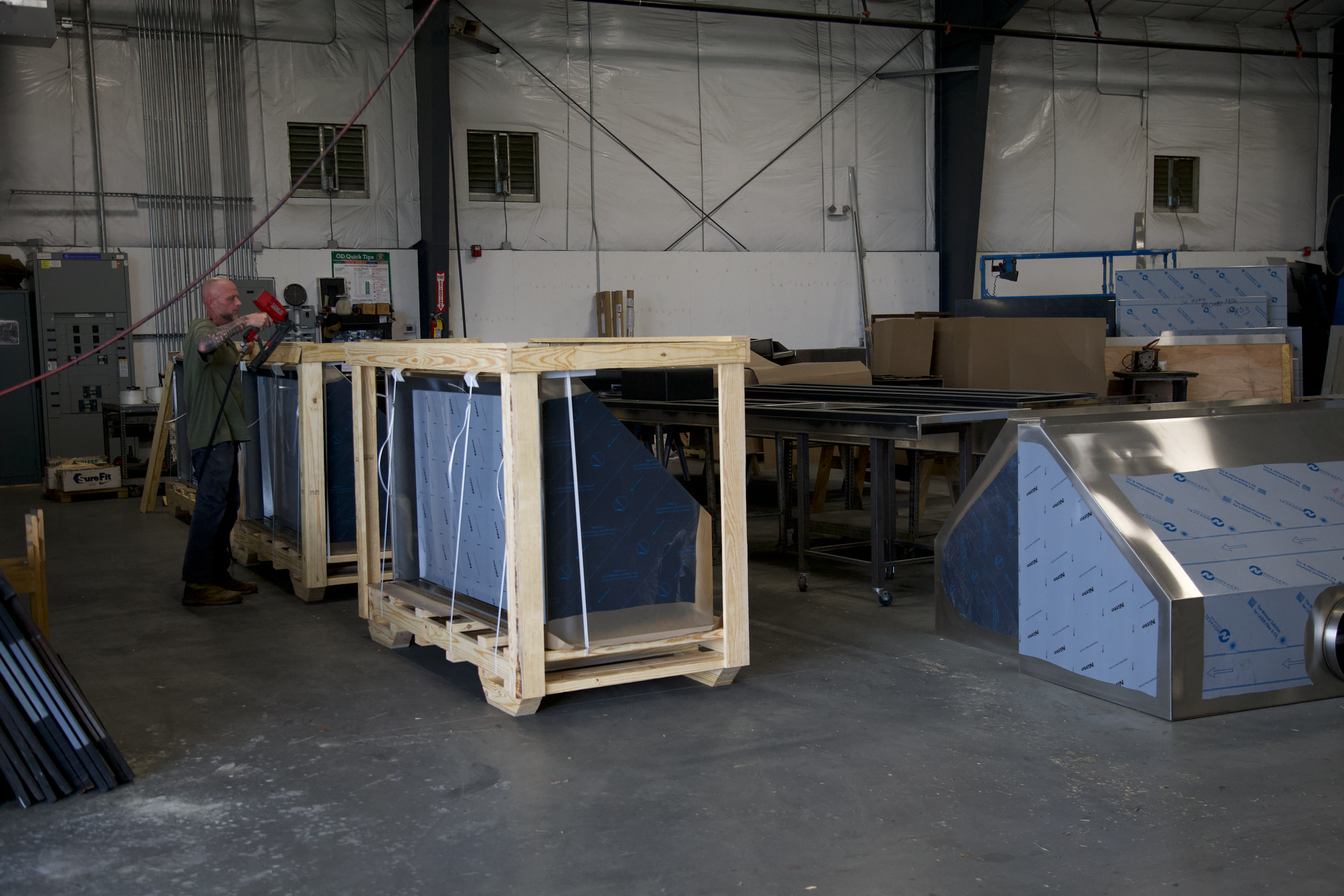A man is standing next to a wooden crate in a factory.