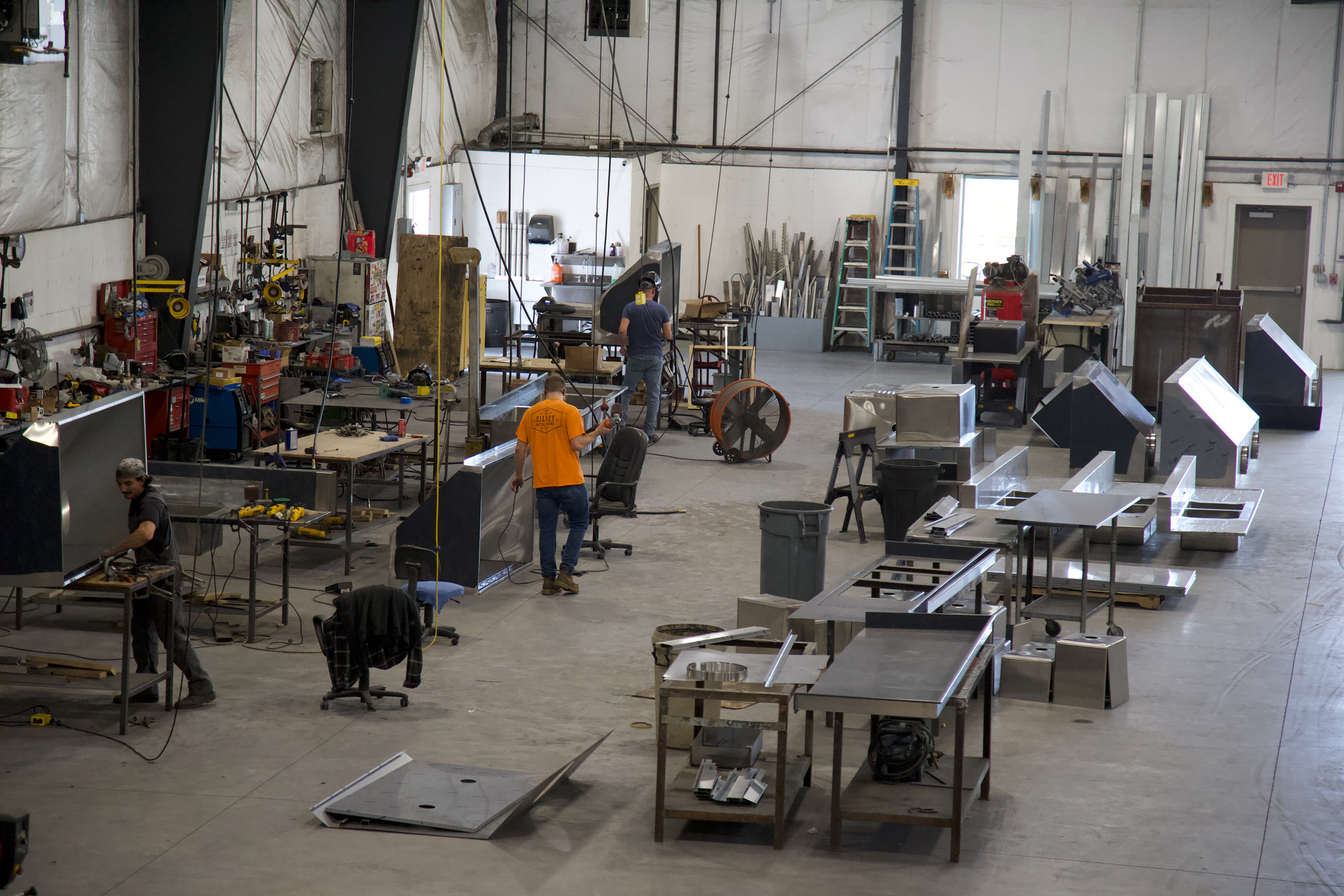 A large warehouse filled with lots of tables and machinery.