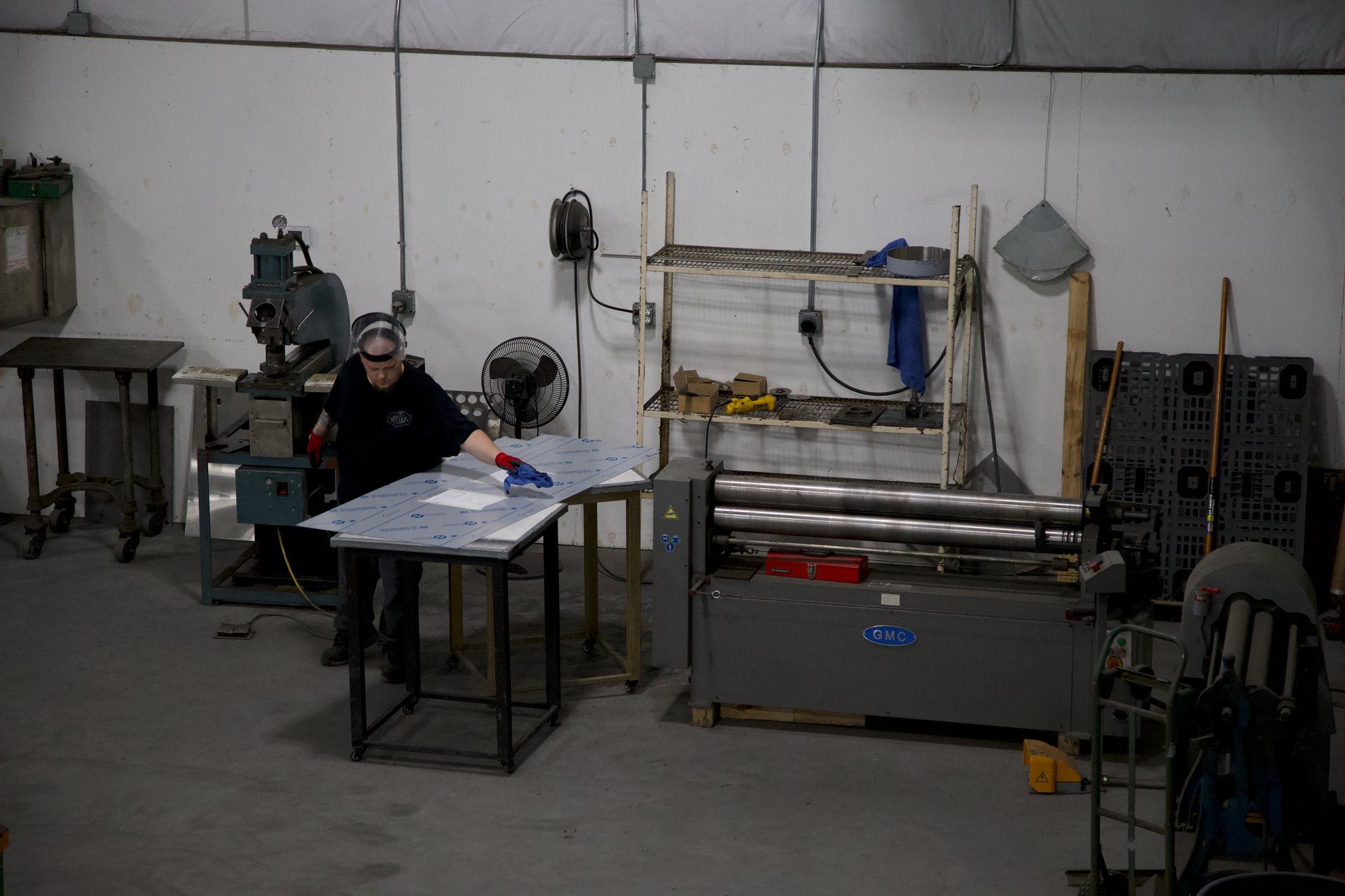 A man is working on a piece of metal in a factory.