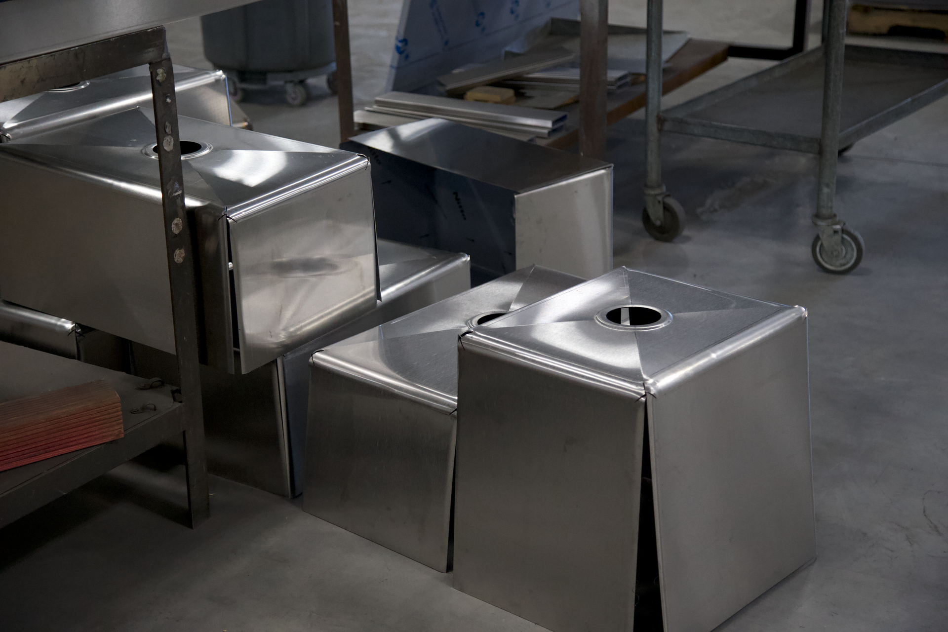 A group of stainless steel boxes sitting on top of each other on a concrete floor.