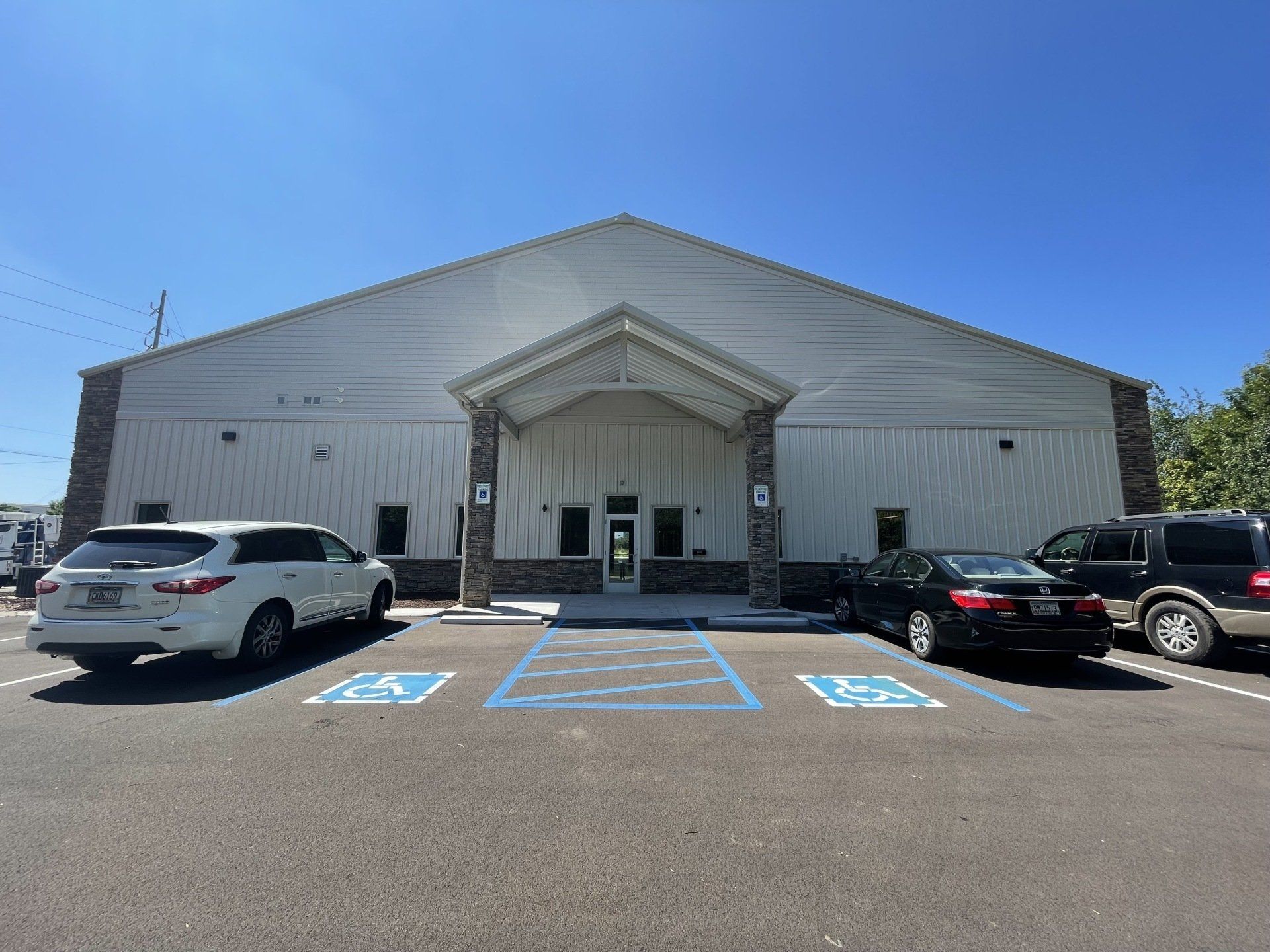 A large white building with cars parked in front of it.