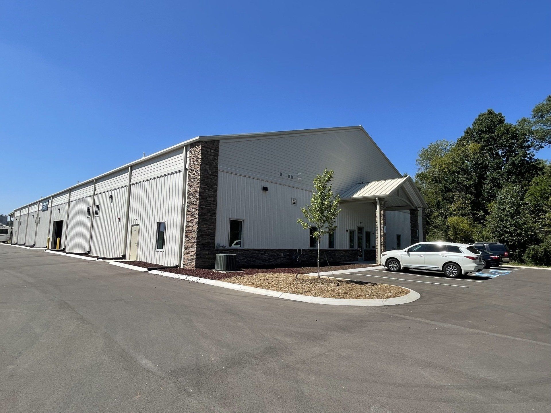 A large white building with cars parked in front of it.