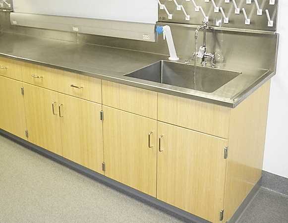 A kitchen counter with a sink and wooden cabinets