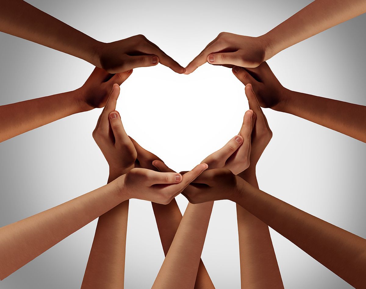 10 hands in a variety of skin tones making a heart shape