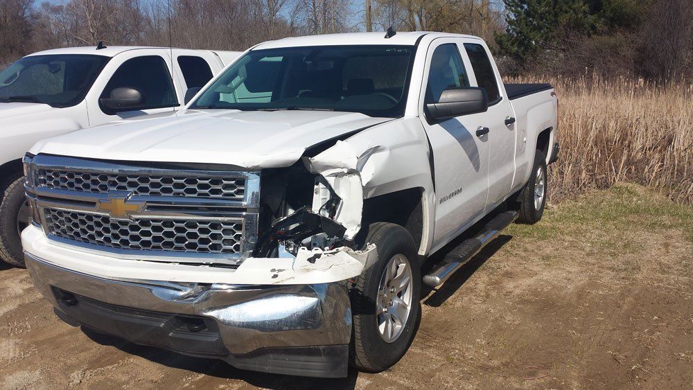 white pickup with damaged headlight