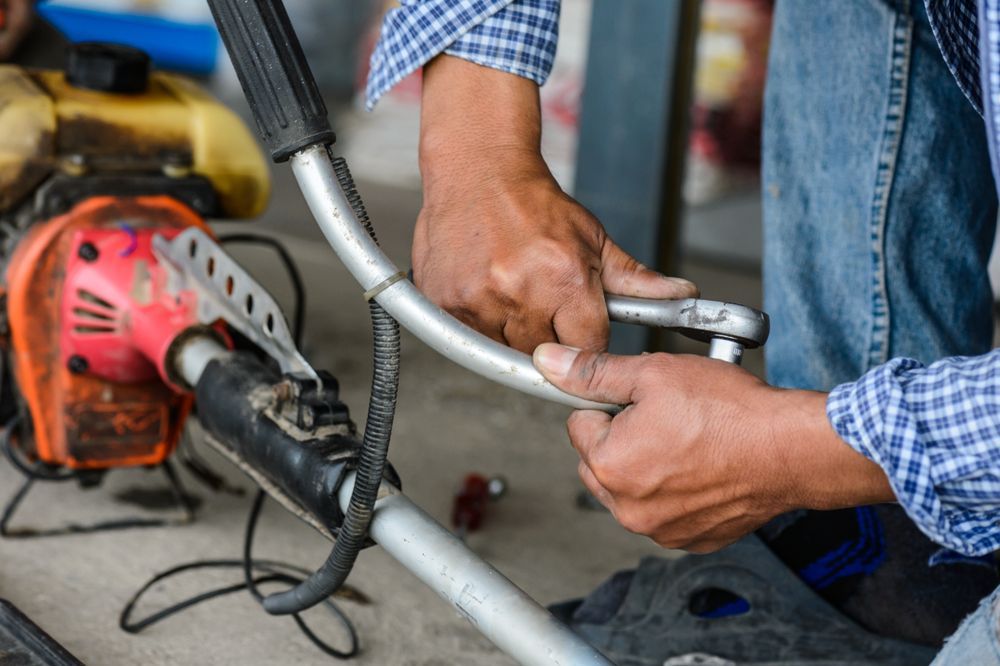 A Person in a Plaid Shirt Uses a Wrench to Tighten Bolts — Aspire Diesel In Duaringa, QLD
