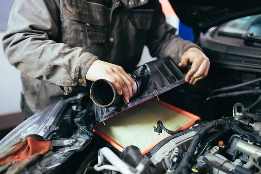 A Man is Working on the Air Filter of a Car — Aspire Diesel In Bouldercombe, QLD