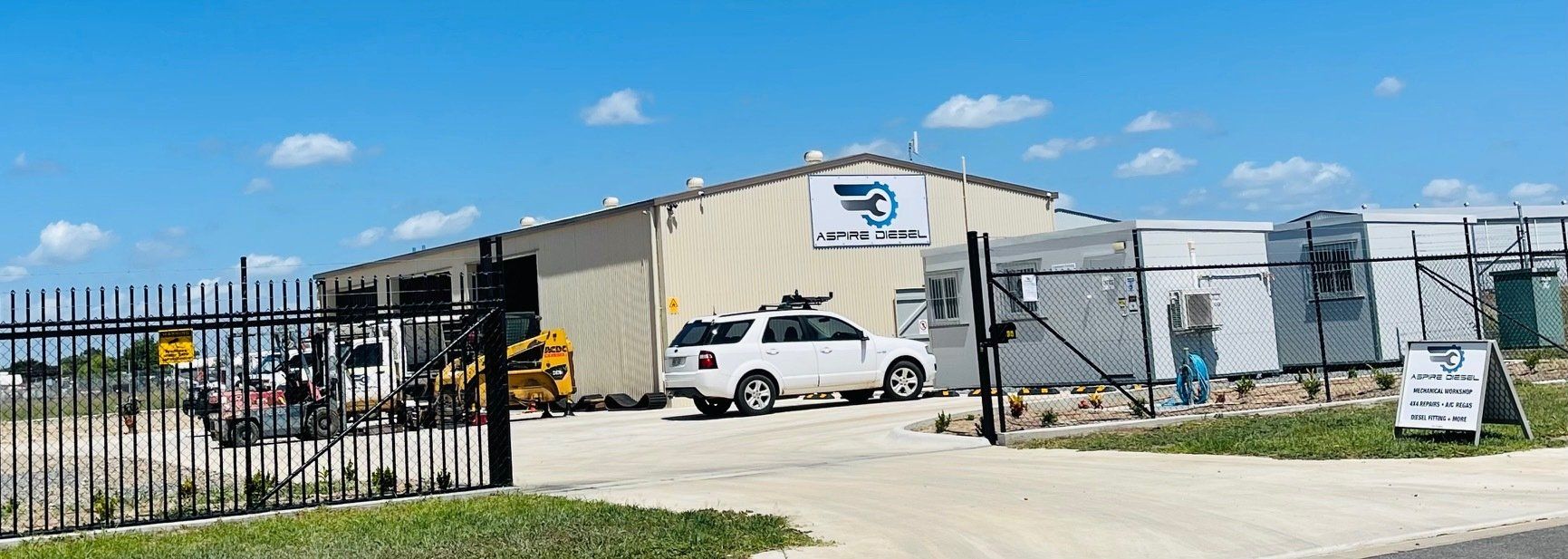 A White SUV Is Parked In Front Of A Large Building — Aspire Diesel In Gracemere, QLD