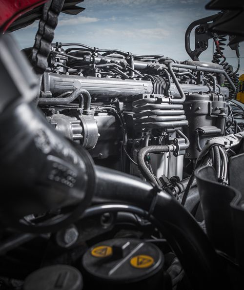 A close up of a car engine with a yellow sticker that says cat