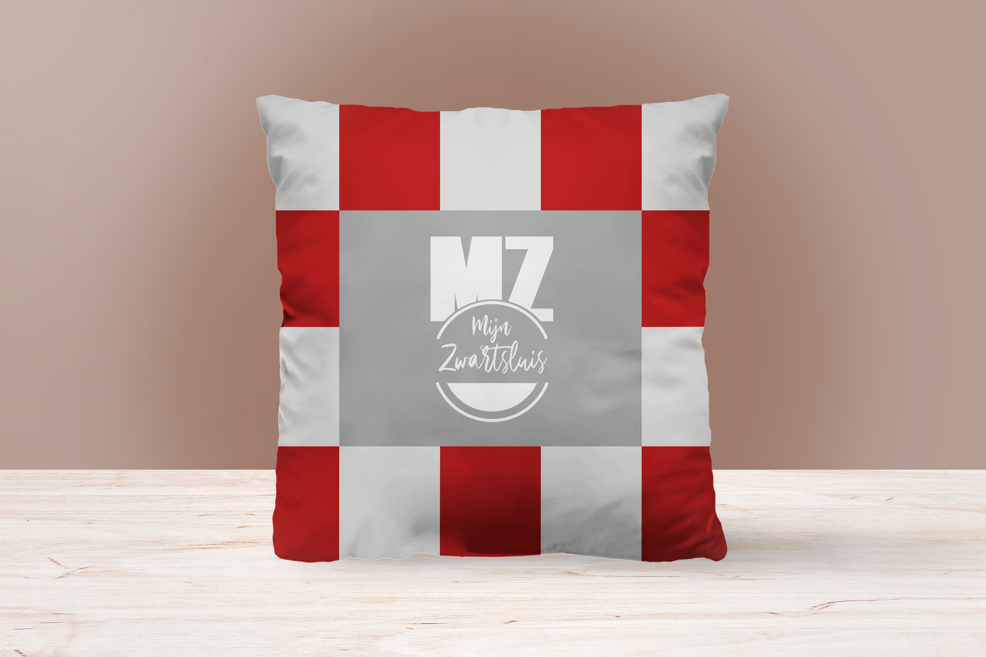 Een rood en wit geruit kussen zit op een houten tafel.