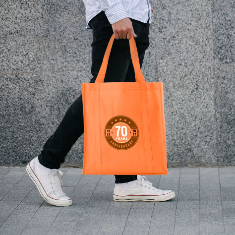 Een man draagt een oranje draagtas met het nummer 70 erop