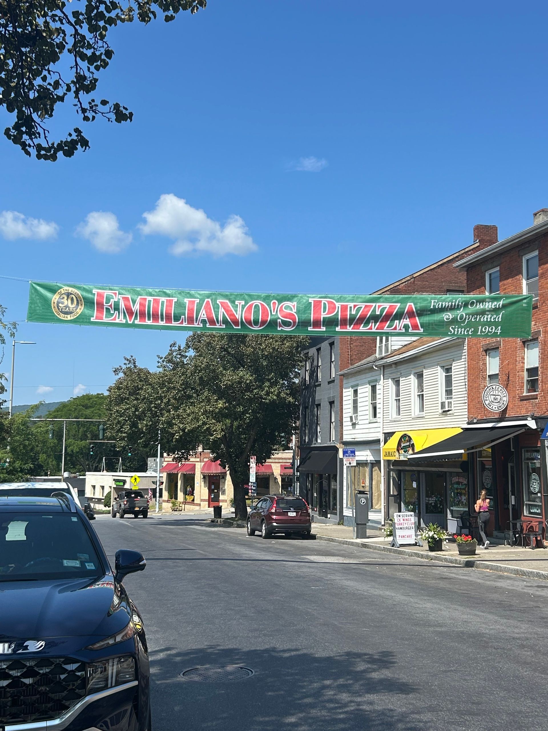 A street with a banner that says emiliano 's pizza